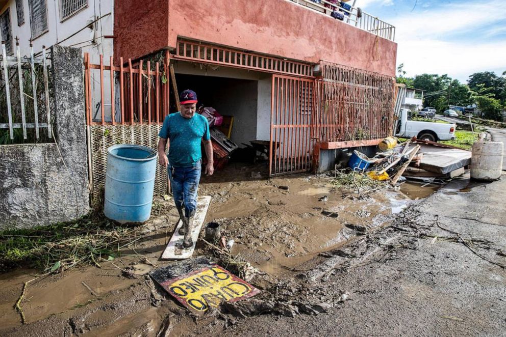 PHOTO: A man walks out of his house through the mud left by the river Rio de la Plata overflowing in the San Jose de Toa Baja, on Sept. 20, 2022, after Hurricane Fiona passed by Puerto Rico.
