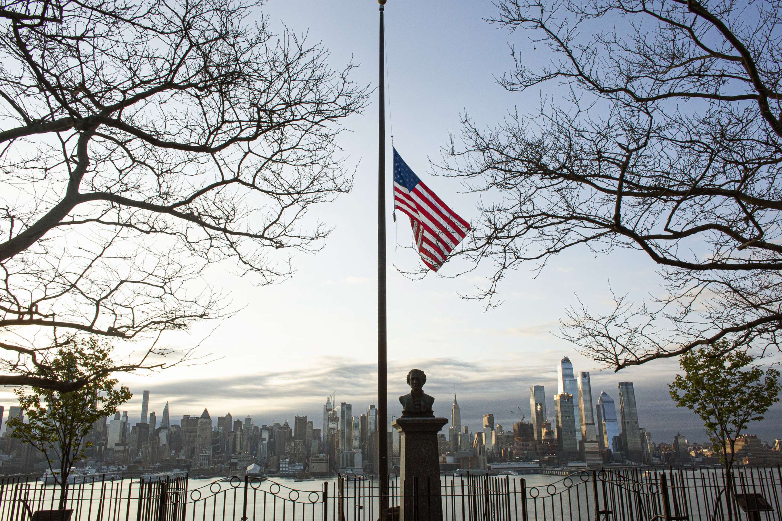 PHOTO: Flags are flying at half-mast as the sun rises behind in Manhattan, April 6, 2020, from Weehawken, New Jersey.