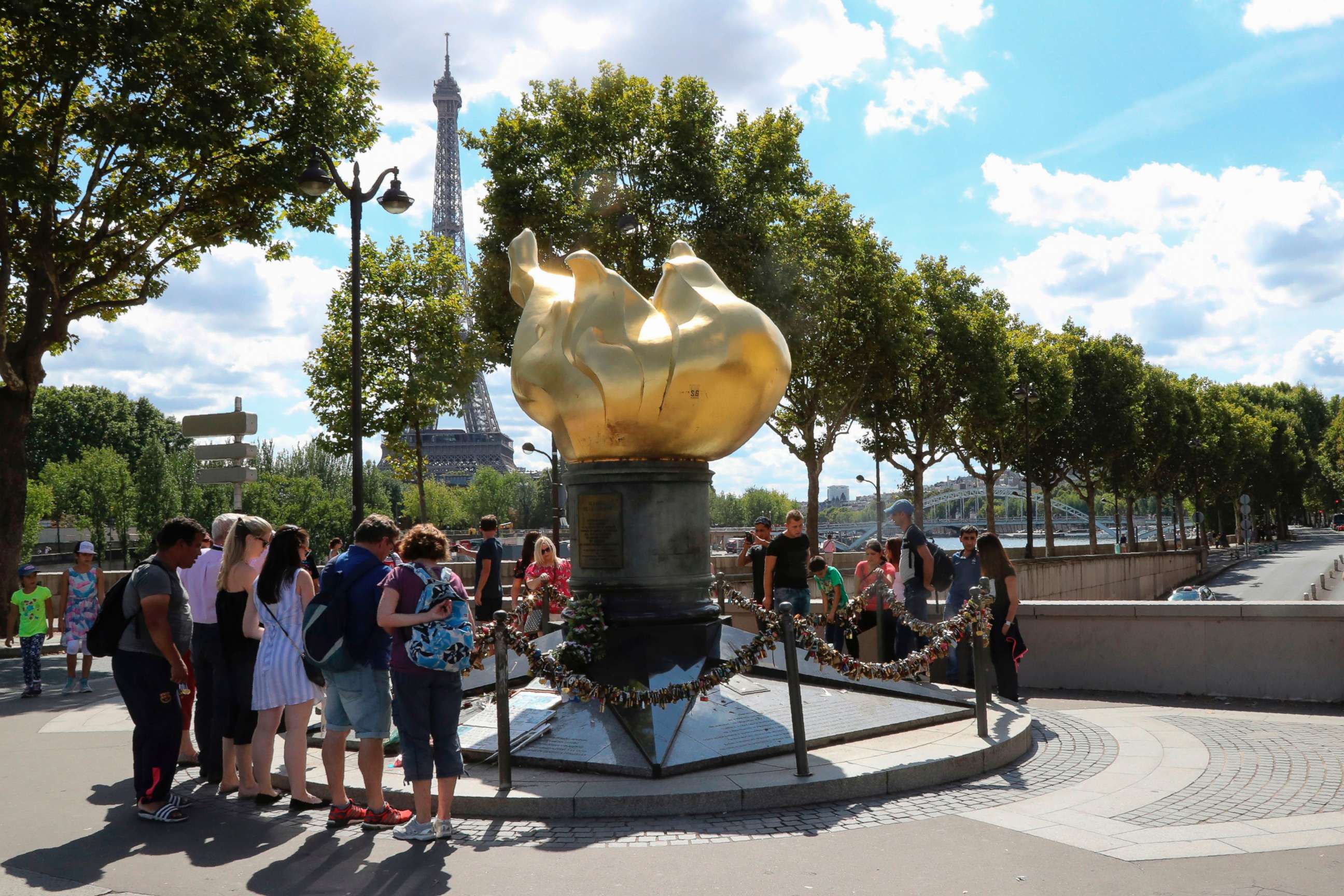 PHOTO: People walk around the "Liberty Flame" where fans memorialized Princess Diana after her death in Paris, Aug. 31, 2017.