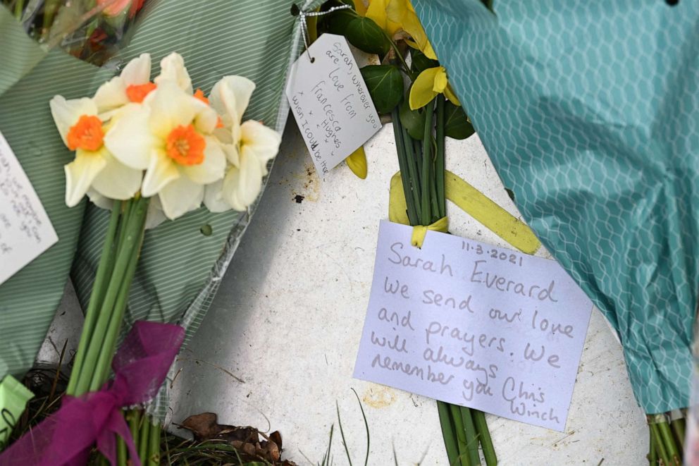 PHOTO: Bunches of flowers and messages of condolence  for Sarah Everard are seen at the woodland where police officers found human remains near Ashford, southeast England, on March 12, 2021.