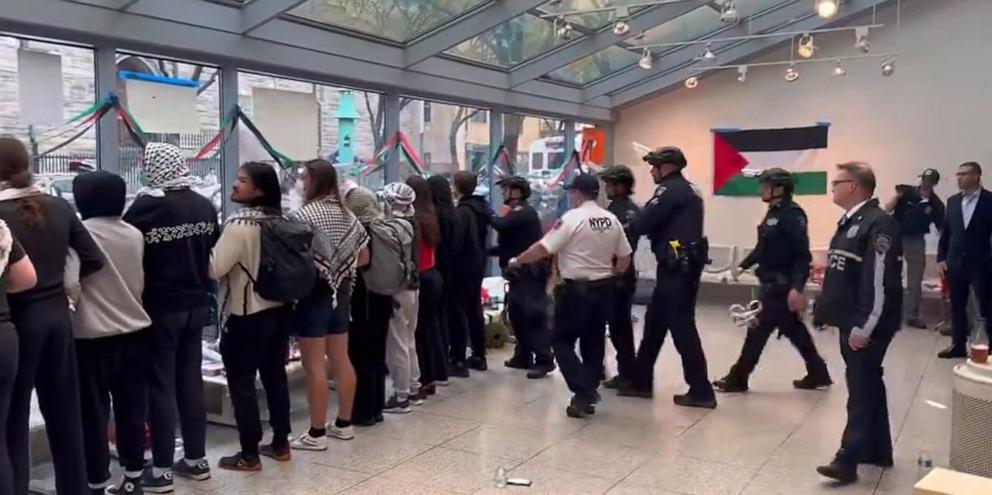 PHOTO: Students at Fordham University's Lincoln Center campus link arms inside a building at NYPD moves in to make arrests, on May 1, 2024, in New York.