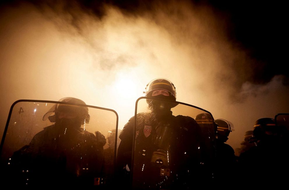 PHOTO: French riot police face protesters at Place de la Bastille as a fire burns behind them as demonstrations against the French Government's Global Security Law turn violent on Nov. 28, 2020, in Paris.