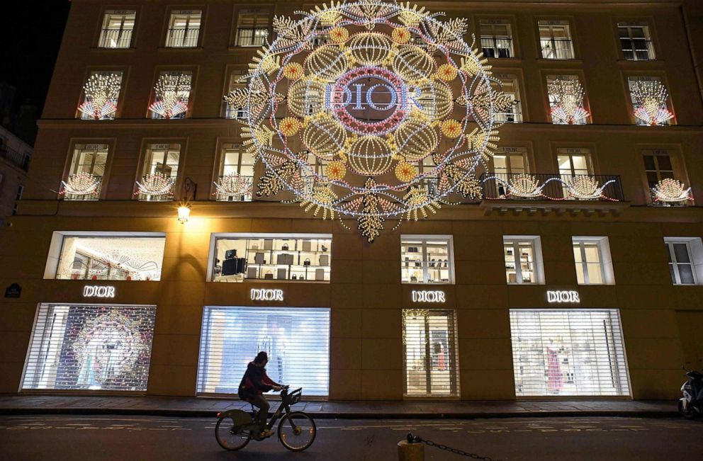 PHOTO: A man rides his bike in front of a Paris luxury goods shop illuminated for the holidays, as a new 8:00 pm-6:00am curfew is implemented in France to avoid a third wave of coronavirus infections, Dec. 15, 2020. 