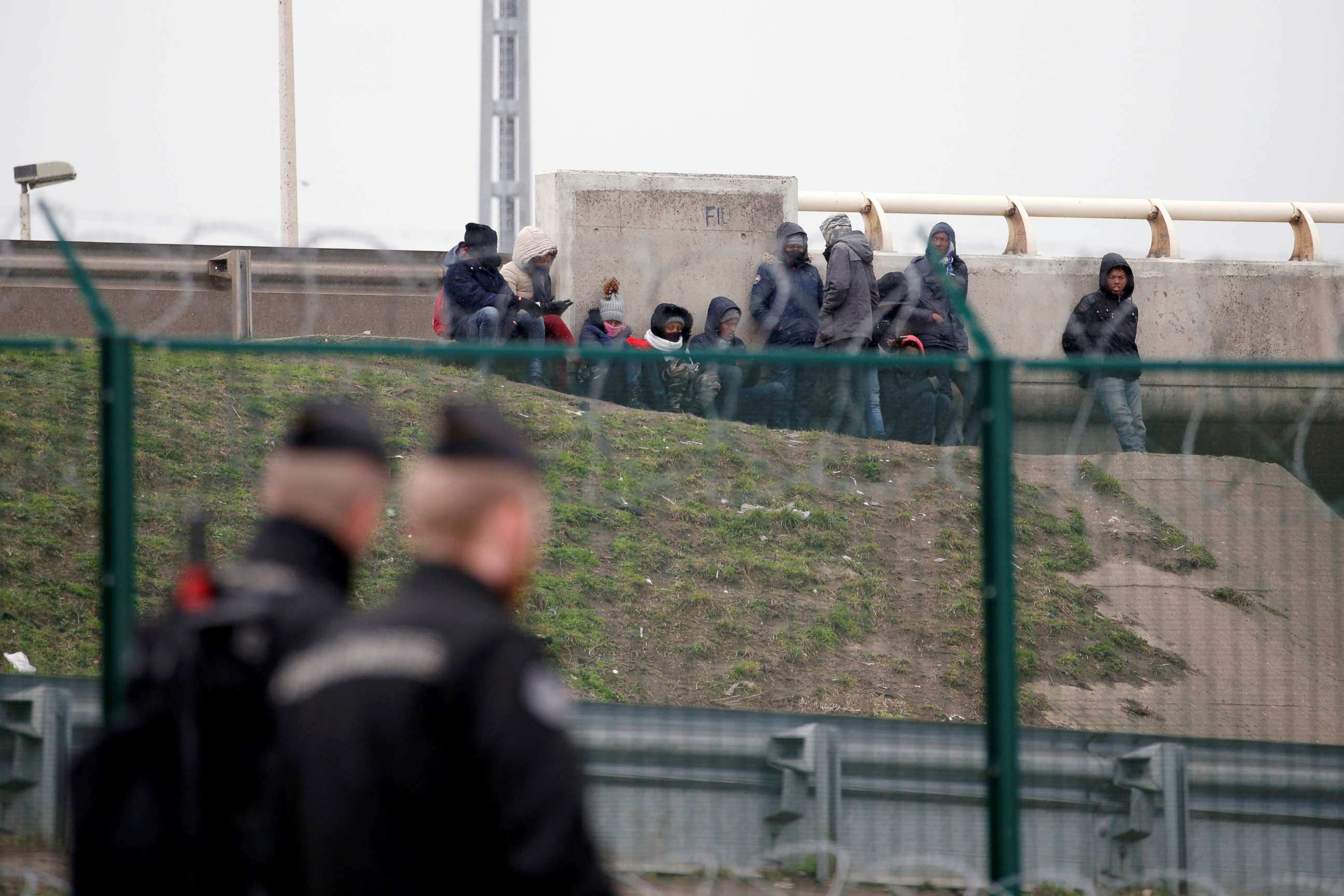PHOTO: Migrants gather near an bridge as French gendarmes patrol the day after a brawl between Erithean and Afghan migrants that left four in critical condition in Calais, France, Feb. 2, 2018.