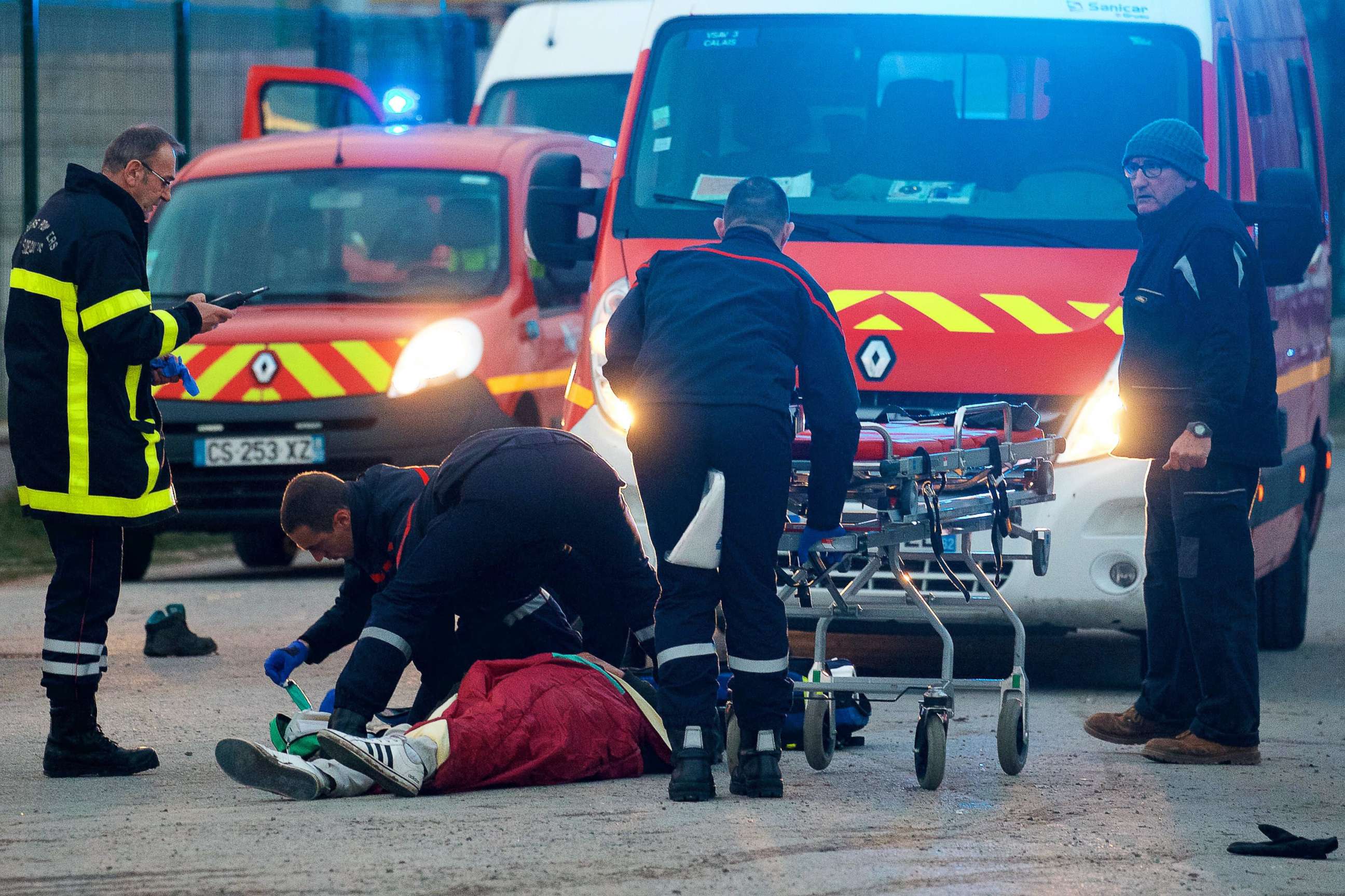 PHOTO: A migrant receives medical assistance by rescue workers following clashes near the ferry port in Calais, northern France, Feb.1, 2018. 