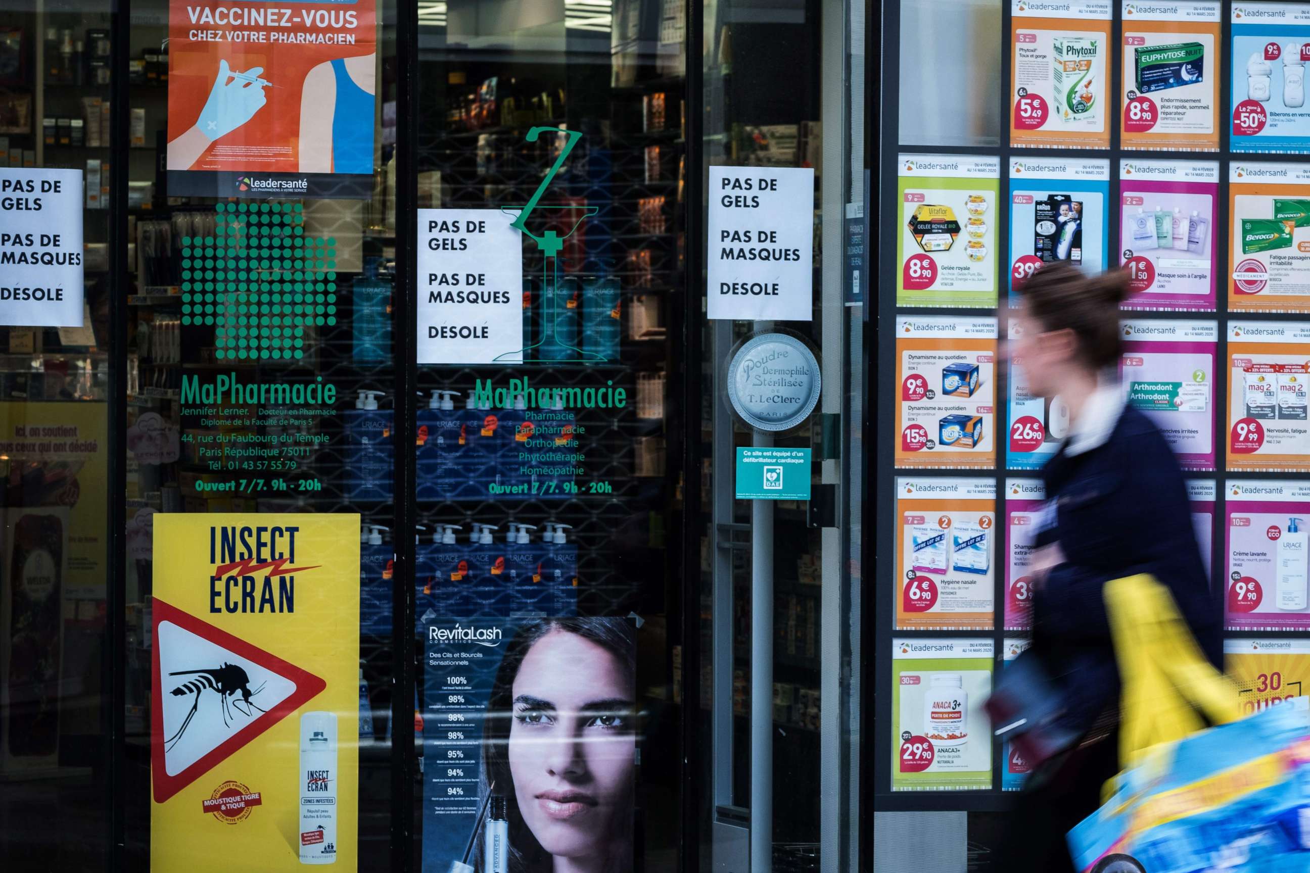 PHOTO: A woman walks past a pharmacy on March 15, 2020, one day after France ordered the closure of all non-essential public places including restaurants and cafes, amid the COVID-19 outbreak.