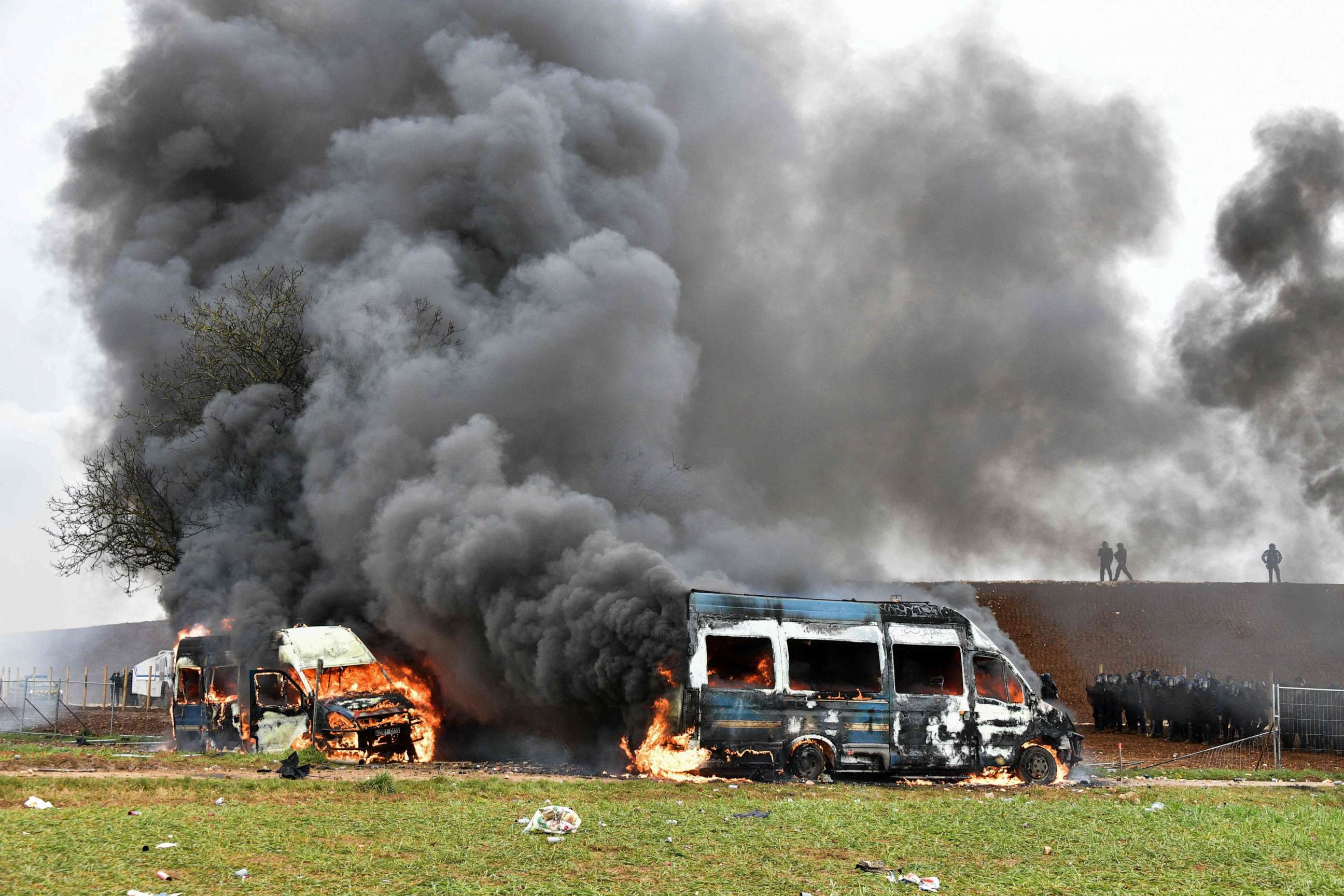 PHOTO: Gendarmes' stand next to their vehicles burning during a demonstration called by the collective "Bassines non merci", to protest against construction of a new water reserve for agricultural irrigation, in Sainte-Soline, France, on Mar. 25, 2023.