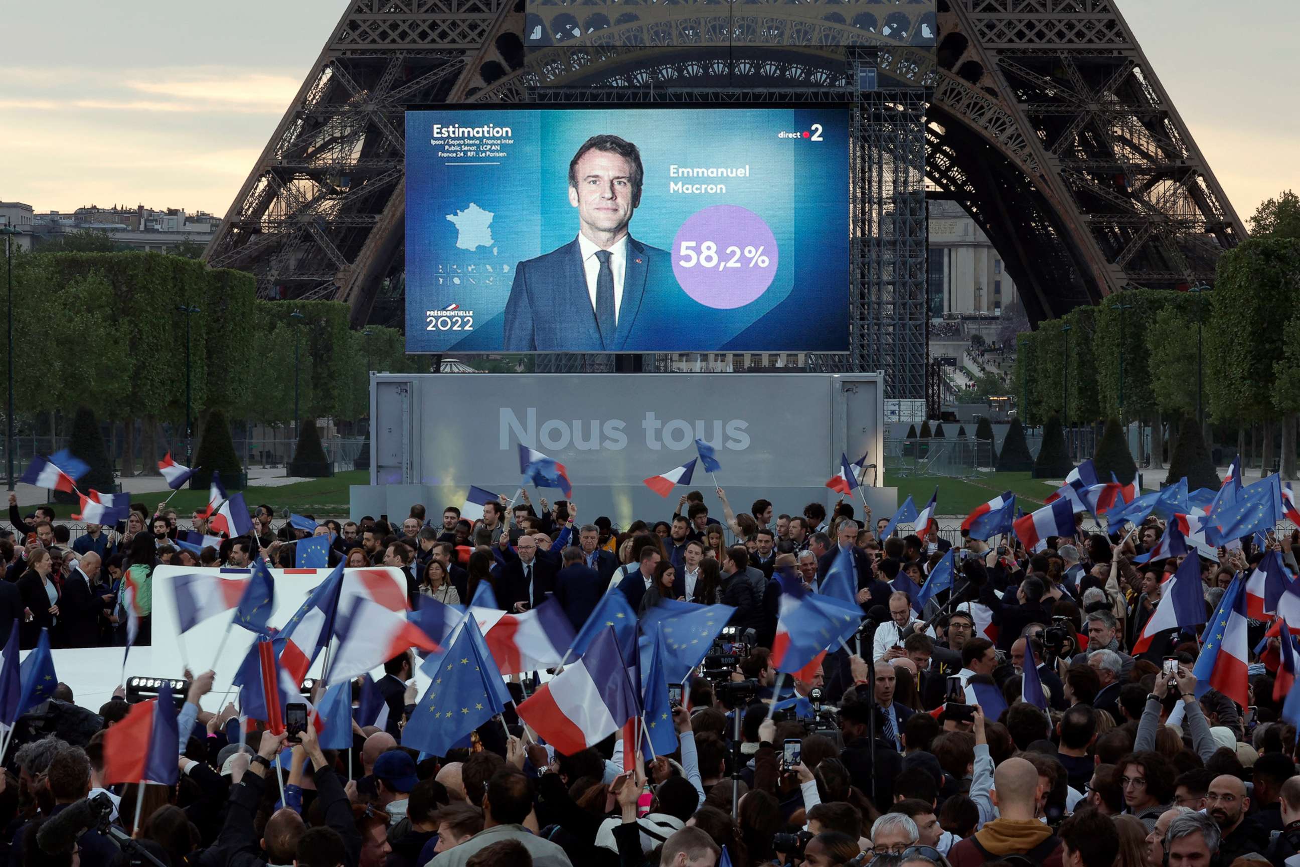 PHOTO: Supporters of French President Emmanuel Macron,  candidate for his re-election,  react after results were announced in the vote of the 2022 French presidential election, near Eiffel Tower, at the Champs de Mars in Paris,  April 24, 2022.