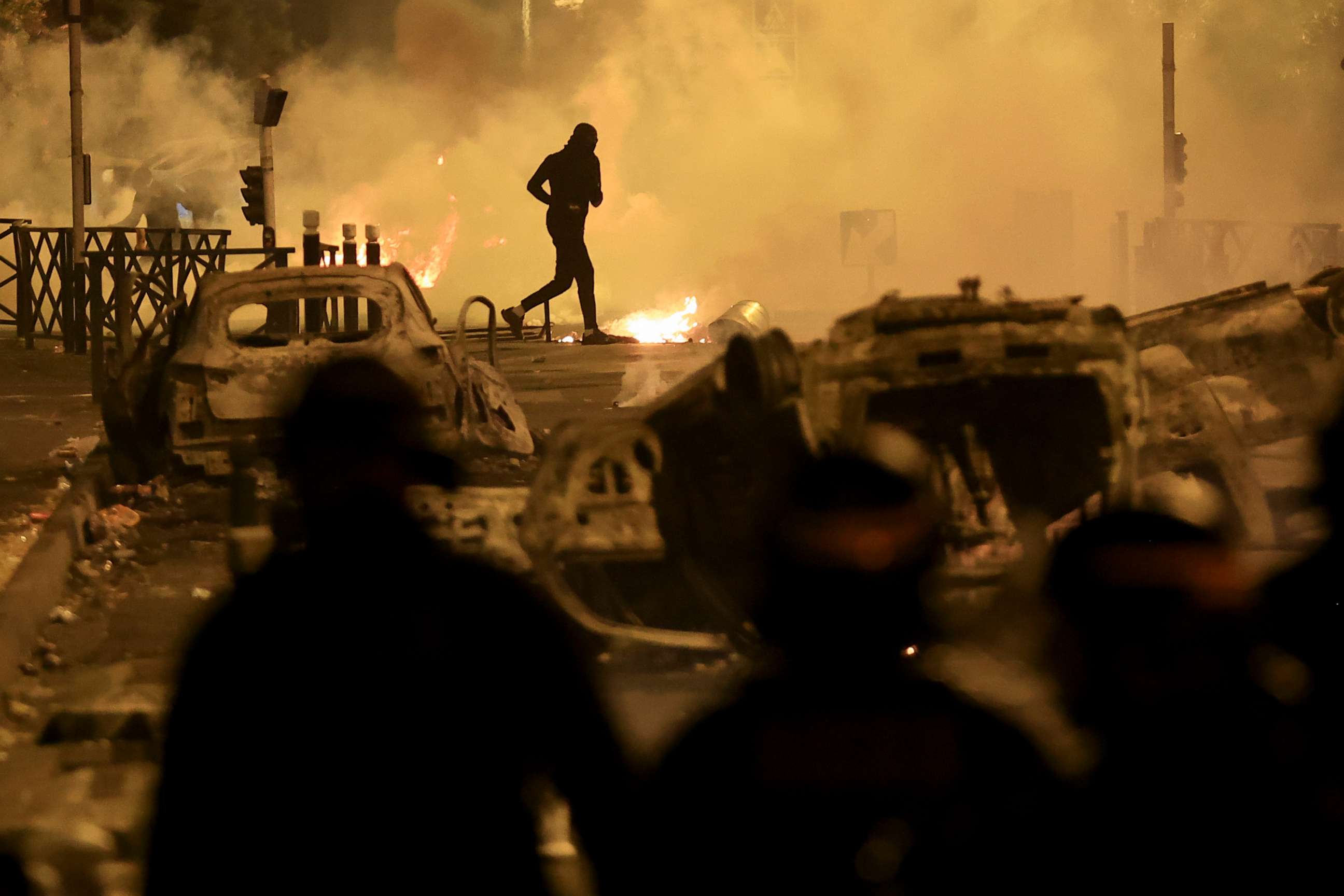 PHOTO: A demonstrator runs on the third night of protests sparked by the fatal police shooting of a 17-year-old driver in the Paris suburb of Nanterre, France, on June 30, 2023.