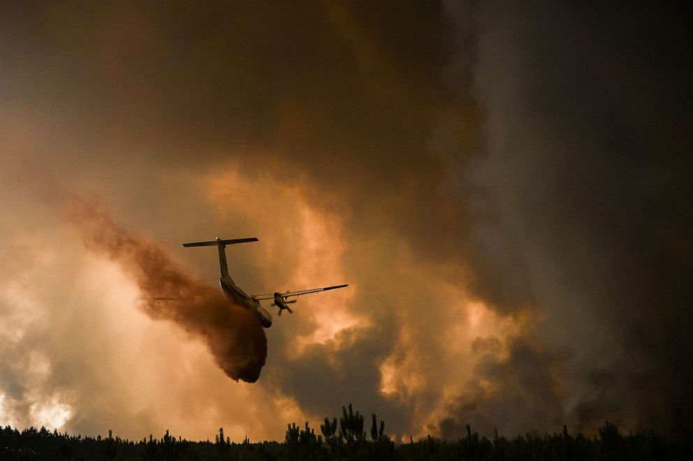 FOTO: Un avión de extinción de incendios rocía retardante de fuego en los árboles durante un incendio cerca de Belin-Beliet en Gironde, suroeste de Francia, el 10 de agosto de 2022. 
