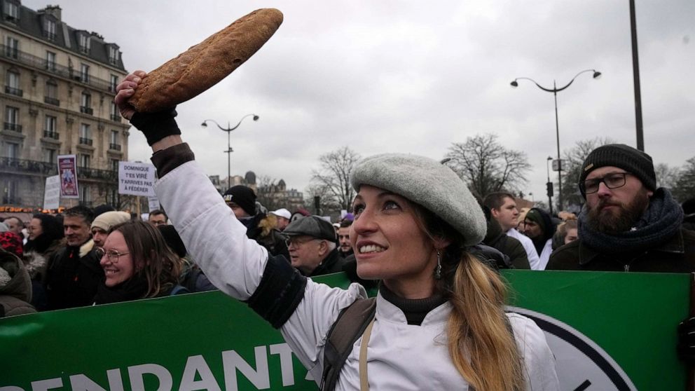 PHOTO: A baker clutches a baguette during a demonstration Monday, Jan. 23, 2023, in Paris.