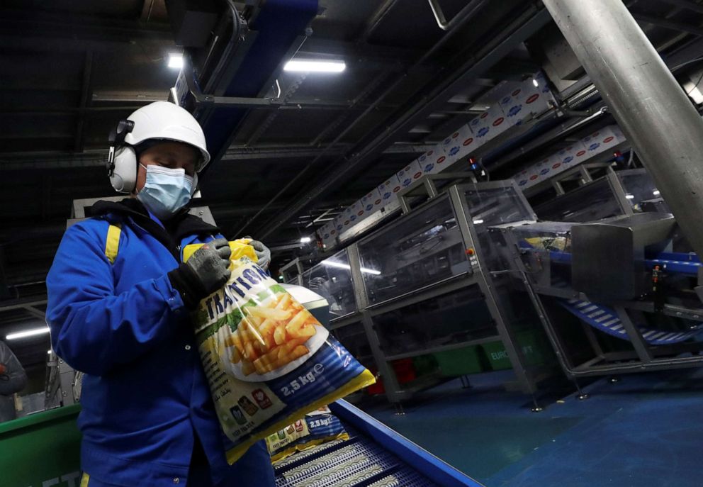 PHOTO: A worker looks at a bag of fresh french fries at Mydibel Group factory, a manufacturer of chilled, frozen and dehydrated potato products, amid the coronavirus pandemic, in Moucron, Belgium, April 29, 2020. 