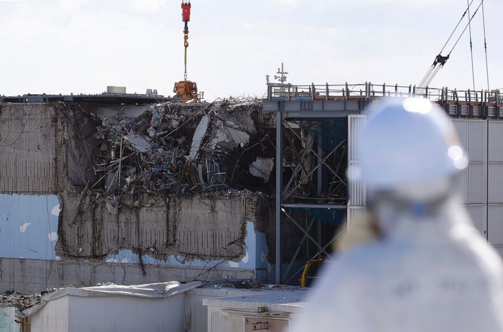PHOTO: In this Feb. 10, 2016 file photo, a member of the media looks at the No. 3 reactor building at Tokyo Electric Power Co's tsunami-crippled Fukushima Dai-ichi nuclear power plant in Okuma, Fukushima Prefecture, northeastern Japan.