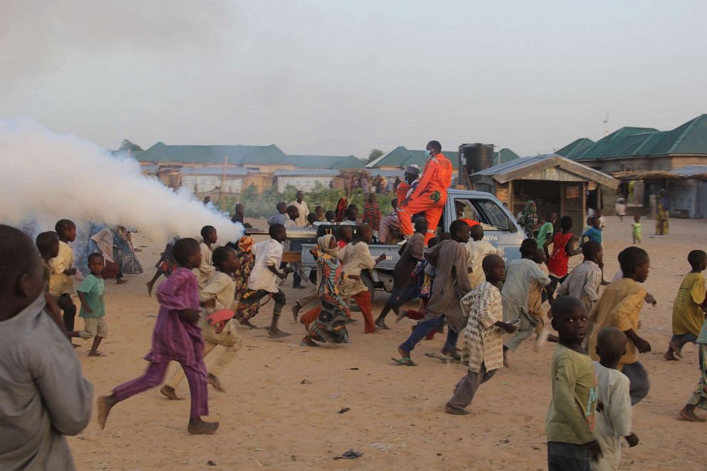 Children playfully run away from a fumigation machine mounted on the back of a pick-up used in a displaced camp in Maiduguri in northeast Nigeria's Borno state on April 15, 2020, as the Borno State Environment Protection Agency proceeds to disinfect the camps as a preventive measure against the spread of the novel coronavirus.Audu Marte/AFP via Getty Images