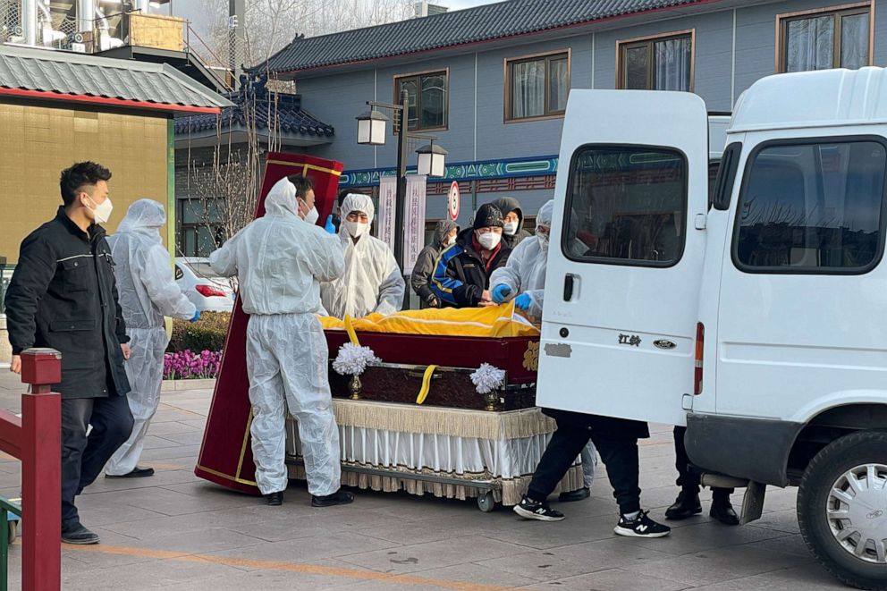 PHOTO: Workers in protective suits transfer a body in a casket at a funeral home, amid the COVID-19 outbreak in Beijing, China, on Dec. 17, 2022.