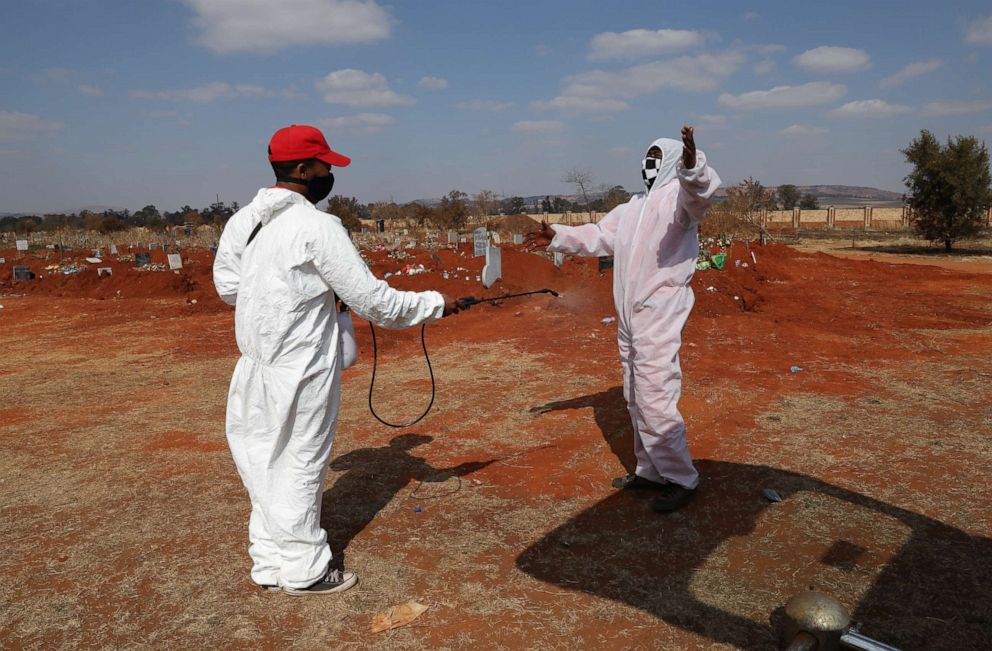PHOTO: Funeral workers wearing personal protective equipment sanitize each other after a burial at the Olifantsvlei cemetery, south-west of Johannesburg, South Africa, on July 28, 2020, during a nationwide lockdown amid the coronavirus pandemic.