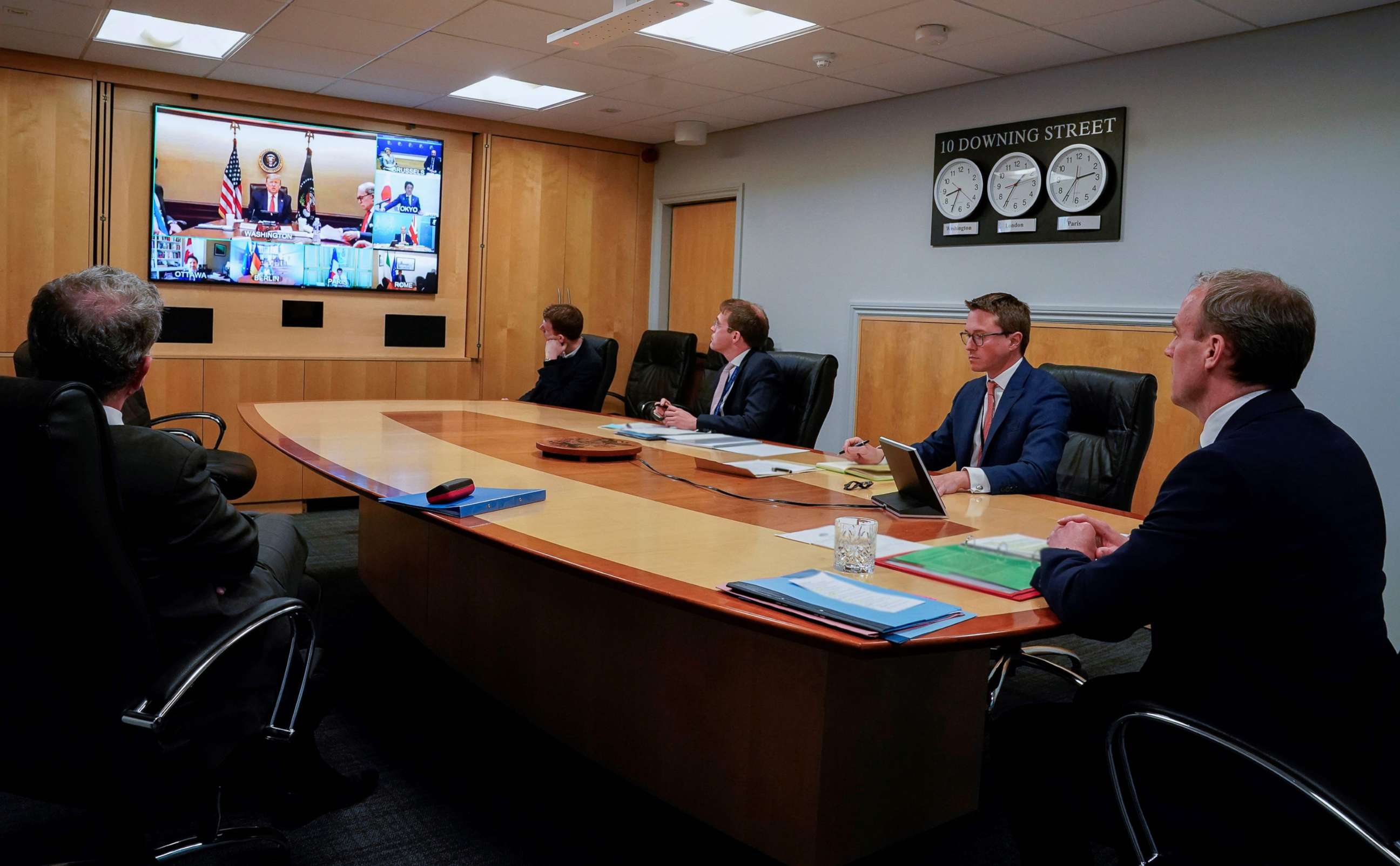 PHOTO: A handout image released by 10 Downing Street, shows President Donald Trump on the screen and Britain's Foreign Secretary Dominic Raab, right, attending a remote G7 meeting inside 10 Downing Street, in central London, on April 16, 2020.