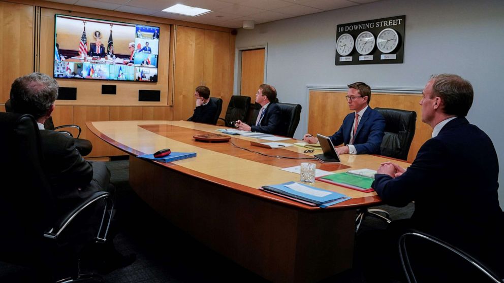 PHOTO: A handout image released by 10 Downing Street, shows President Donald Trump on the screen and Britain's Foreign Secretary Dominic Raab, right, attending a remote G7 meeting inside 10 Downing Street, in central London, on April 16, 2020.