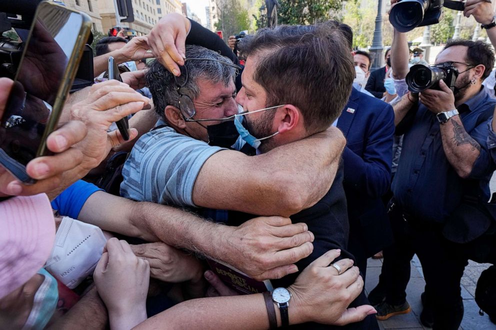 PHOTO: Chilean President-elect Gabriel Boric, center, greets supporters as he leaves the La Moneda presidential palace after meeting with President Sebastian Pinera in Santiago, Chile, Dec. 20, 2021.