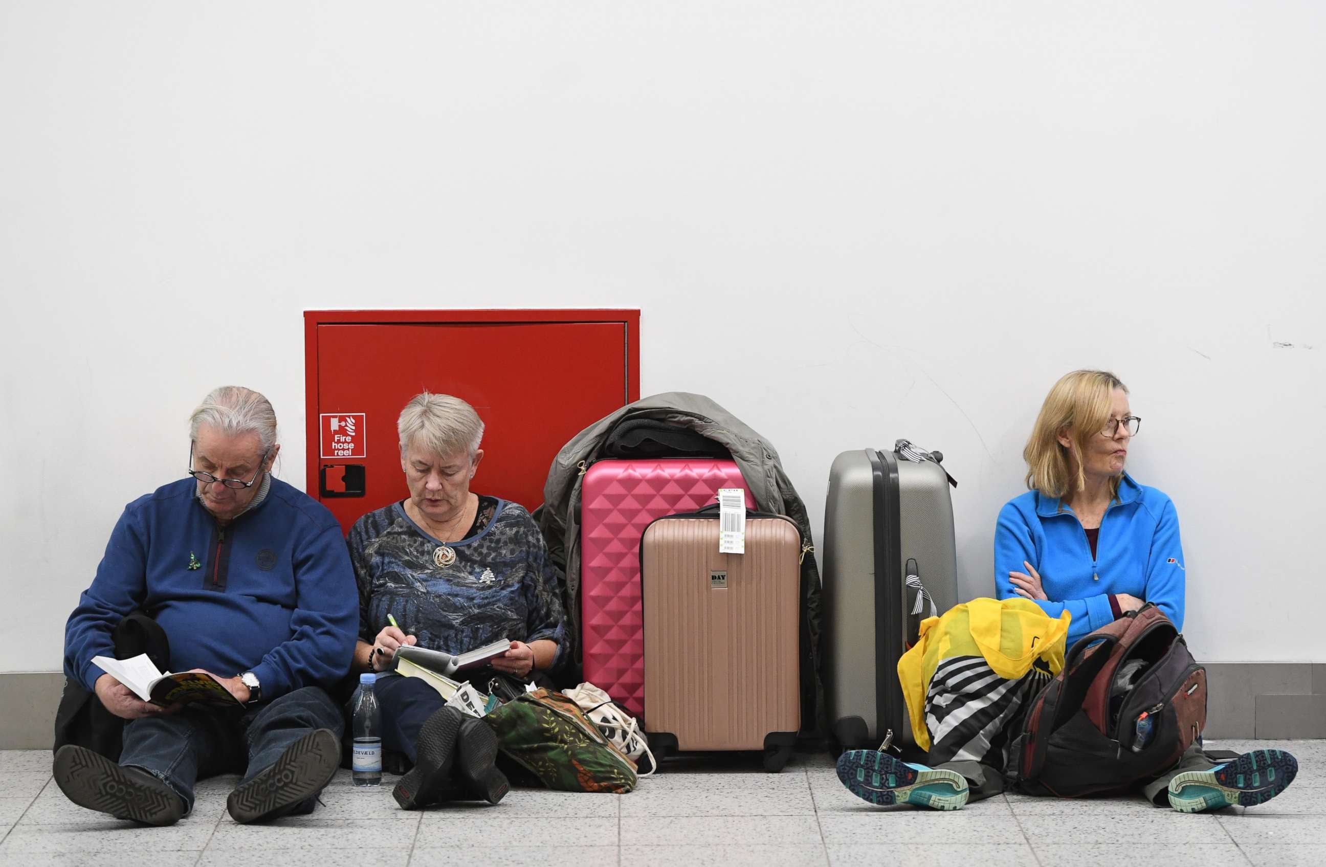 PHOTO: Passengers rest with their luggage at the Gatwick airport in Sussex, southeast, England, Dec. 21, 2018.