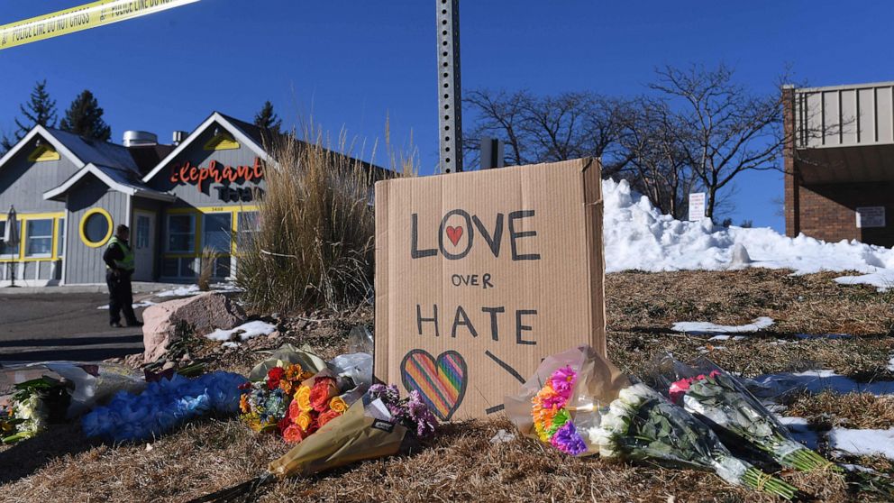PHOTO: Bouquets of flowers and a sign that reads "love over hate" are left near Club Q, an LGBTQ nightclub in Colorado Springs, Colorado on November 20, 2022. 