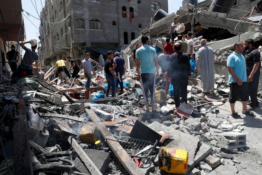 PHOTO: People inspect the rubble of destroyed residential building which was hit by Israeli airstrikes, in Beit Lahiya, Gaza Strip, May 20, 2021.