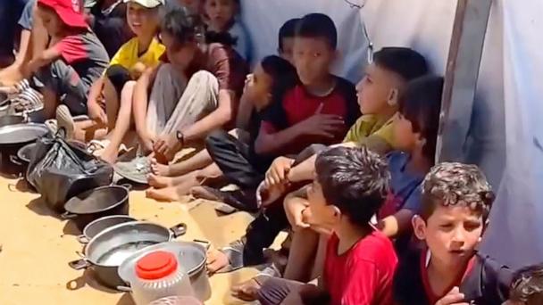 Children line up waiting for food in Gaza amid humanitarian crisis.