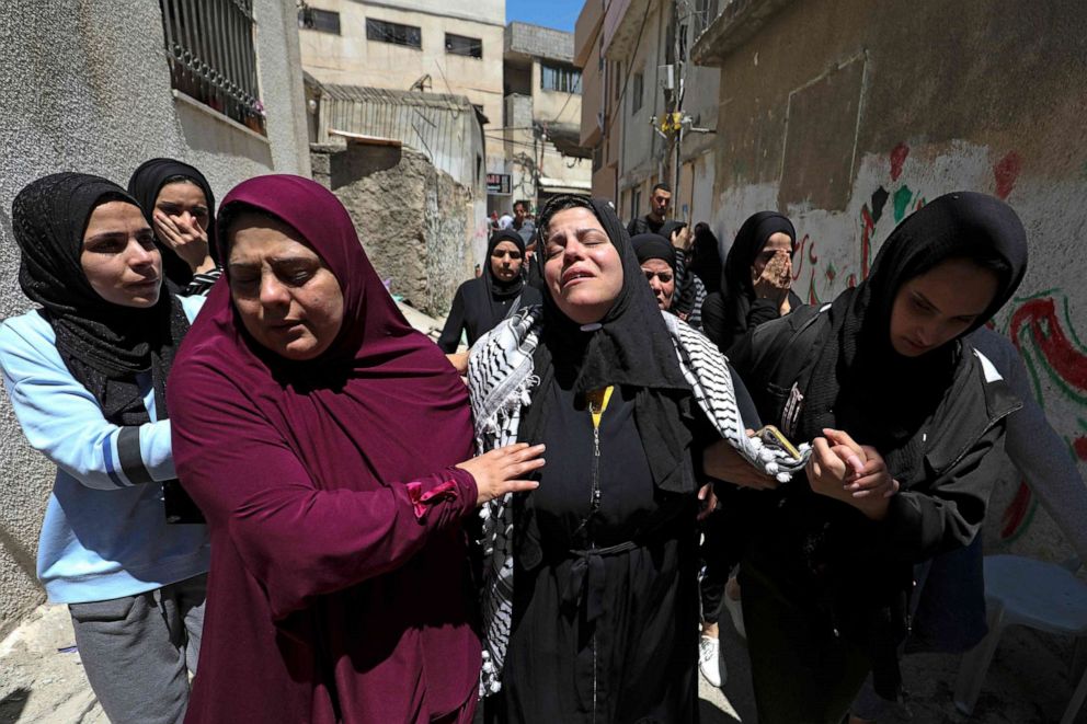 PHOTO: Relatives comfort the mother of Palestinian Ahmad Jameel Fahad, who was killed by Israeli forces in a predawn raid, during the funeral in the Al-Amari refugee camp near Ramallah in the Israeli-occupied West Bank on May 25, 2021.