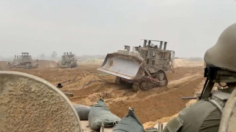 PHOTO: An Israel Defense Forces armoured vehicle waits as armoured bulldozers clear path in a location given as Gaza in this screengrab obtained from a handout video released on Oct. 29, 2023.