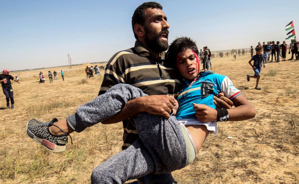 PHOTO: An injured Palestinian boy is carried away from the border fence during clashes with Israeli forces following a protest in the southern Gaza Strip, May 15, 2019.