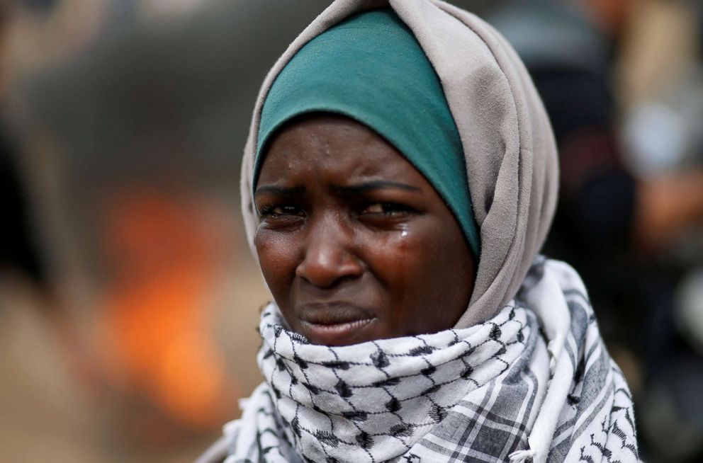 PHOTO: A woman demonstrator reacts to tear gas fired by Israeli troops during clashes at a protest at the Israel-Gaza border where Palestinians demand the right to return to their homeland, east of Gaza City, April 20, 2018.