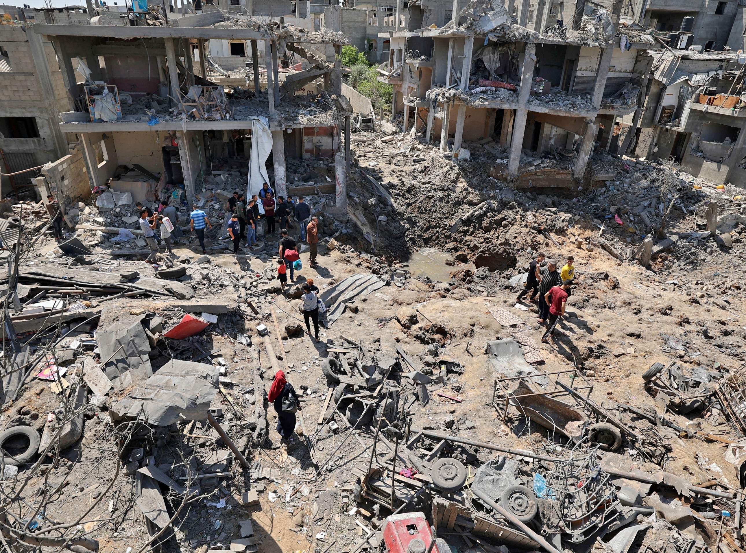 PHOTO: Palestinians assess the damage caused by Israeli air strikes, in Beit Hanun in the northern Gaza Strip, on May 14, 2021.
