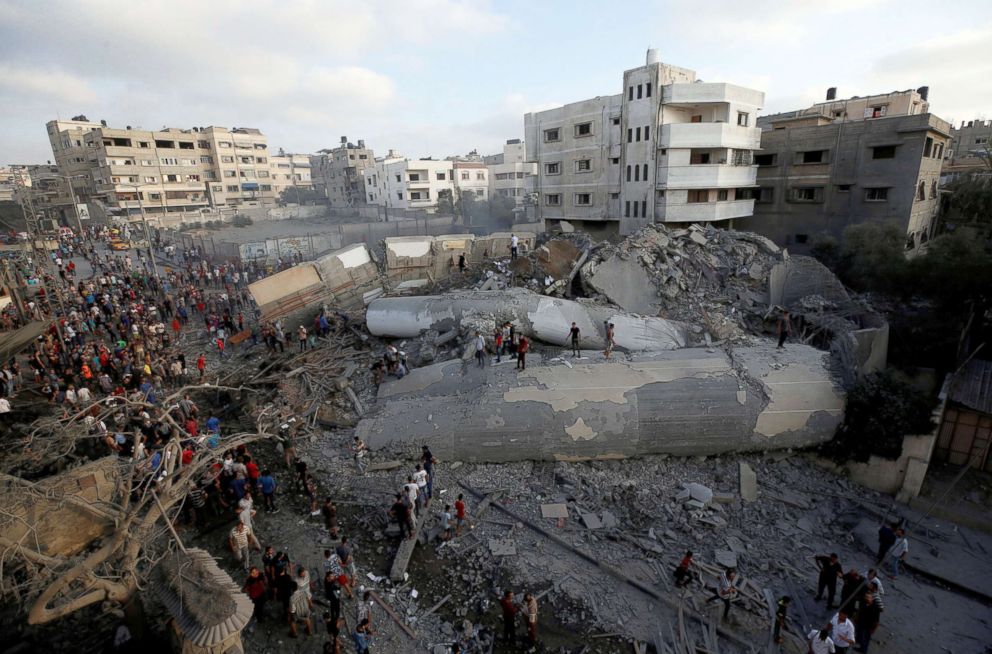 PHOTO: Palestinians gather around a building after it was bombed by an Israeli aircraft, in Gaza City, Aug. 9, 2018.