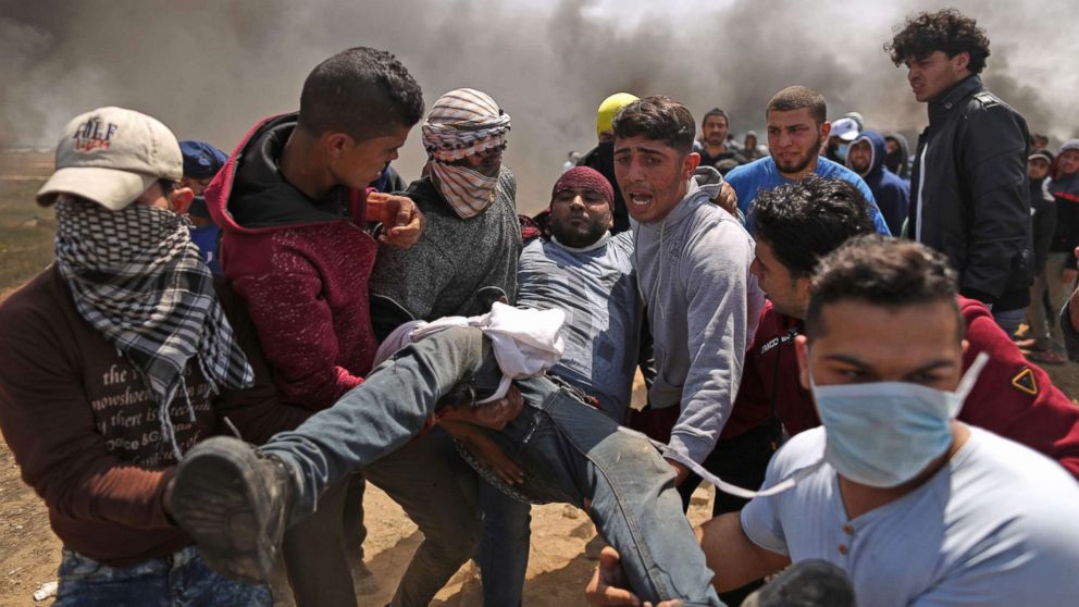 PHOTO: Palestinian men carry an injured protester after clashes with Israeli forces at the Israel-Gaza border during a protest, east of Gaza City in the Gaza strip, April 6, 2018.