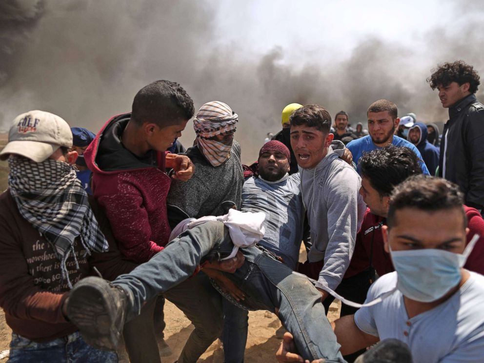 PHOTO: Palestinian men carry an injured protester after clashes with Israeli forces at the Israel-Gaza border during a protest, east of Gaza City in the Gaza strip, April 6, 2018.