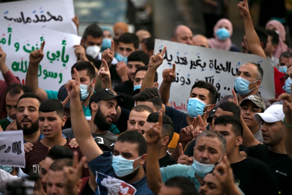 PHOTO: Palestinians hold banners during a protest against French President Macron's remarks on the cartoons of the Prophet Mohammed, in the West Bank city of Ramallah, Oct. 27, 2020.