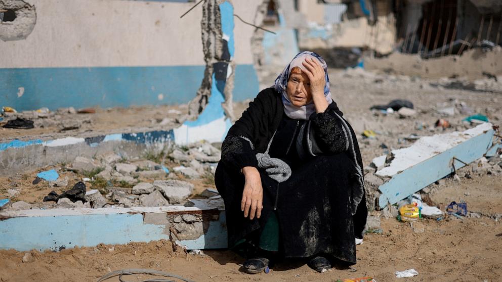 PHOTO: A woman rests next to a damaged building, as Palestinian arrive in Rafah after they were evacuated from Nasser hospital in Khan Younis due to the Israeli ground operation in the southern Gaza Strip, Feb. 15, 2024. 