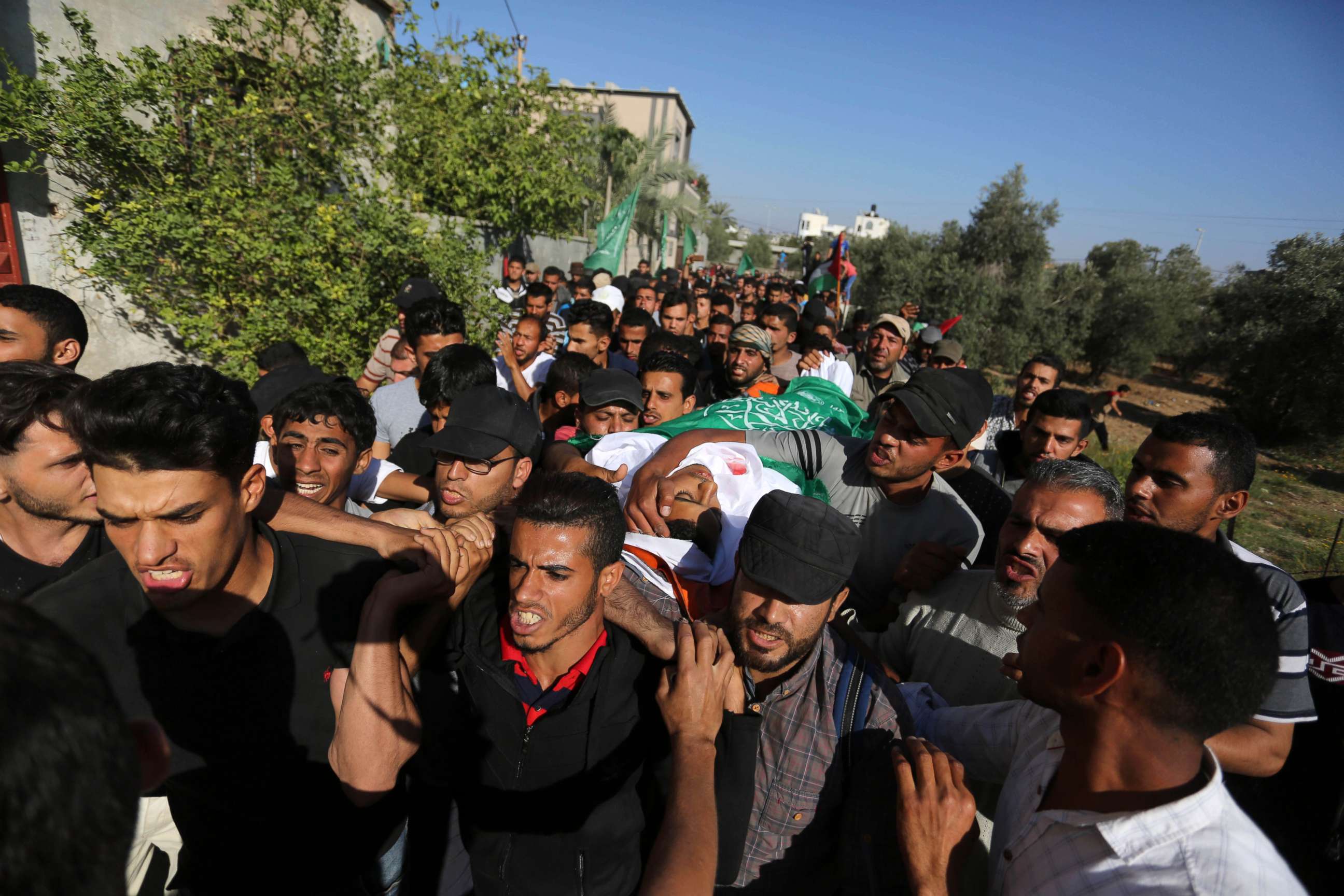 Mourners carry the body of Palestinian Mahmoud Abu Taima, who was killed by Israeli troops during clashes in a tent city protest where Palestinians demanded the right to return to their homeland, May 14, 2018, in the Gaza Strip.
