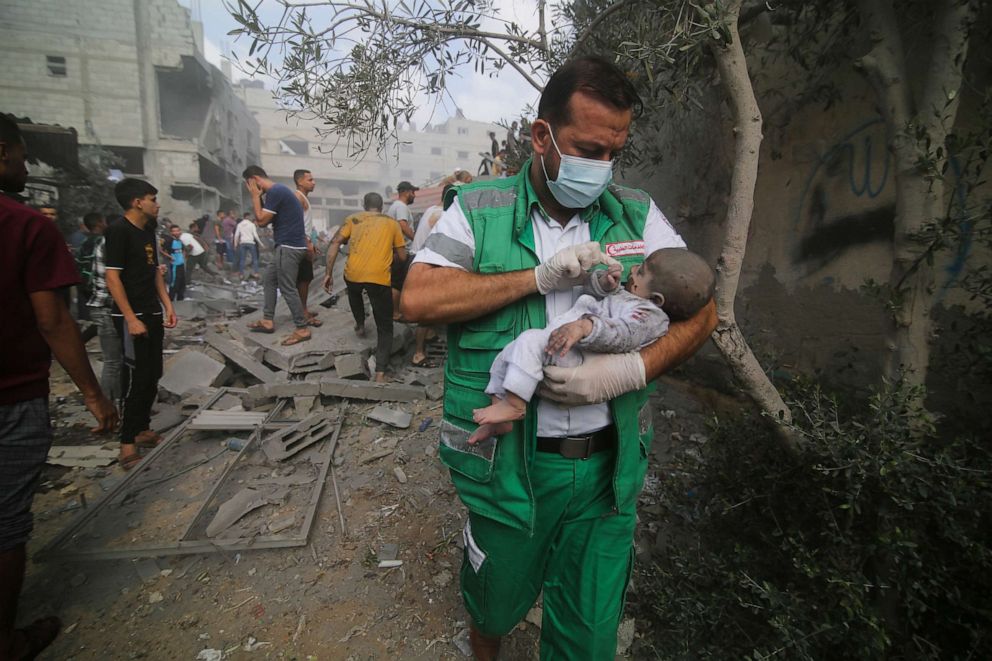 PHOTO: Palestinian medic takes a baby pulled out of buildings destroyed in the Israeli bombardment of the Gaza Strip in Rafah, Oct. 22, 2023.