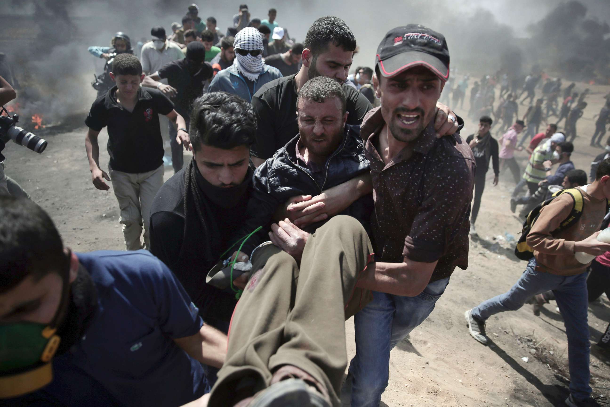 PHOTO: Palestinian protesters carry an injured man who was shot by Israeli troops during a protest at the Gaza Strip's border with Israel, May 14, 2018.