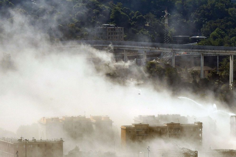 PHOTO:A cloud of smoke covers the site after explosive charges blew up the eastern pylons of Genoa's Morandi motorway bridge, June 28, 2019, in Genoa, Italy.