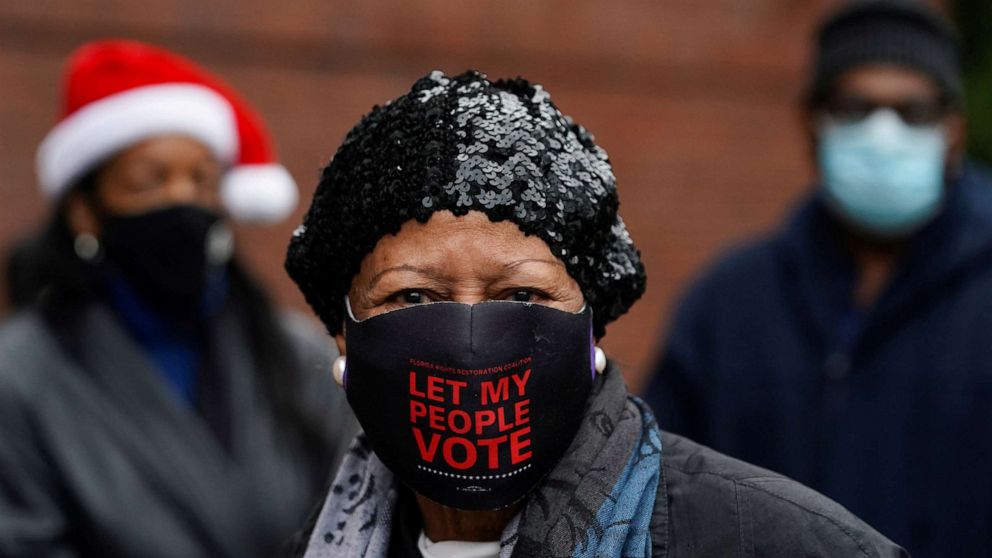 PHOTO: Lillian Roberts wears a face mask reading 'Let my people vote' while waiting in line to cast her ballot in the U.S. Senate runoff elections on the first day of early voting in Atlanta, Dec. 14, 2020.
