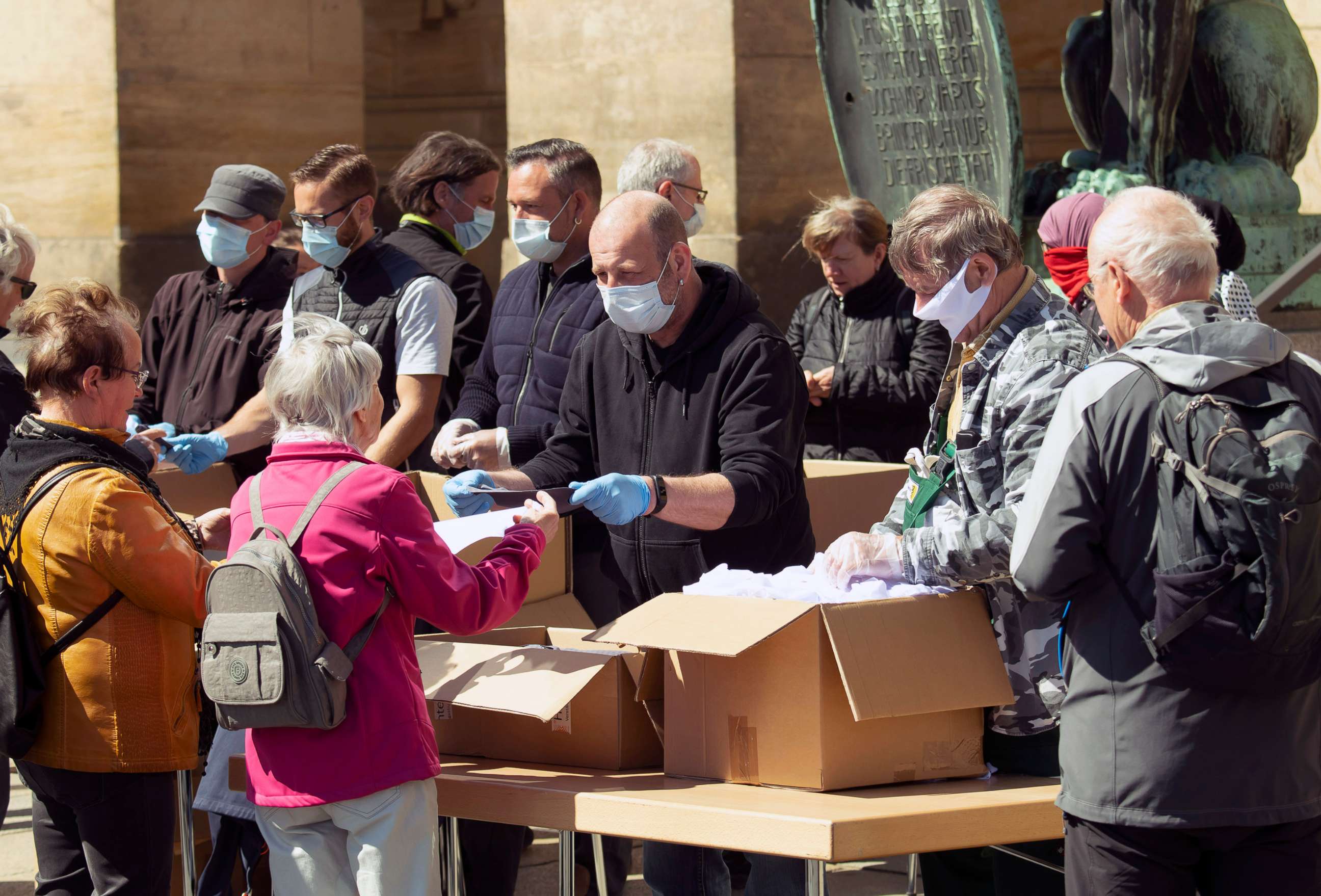 PHOTO: City administration helpers hand out face masks in Dresden, eastern Germany, April 20, 2020.