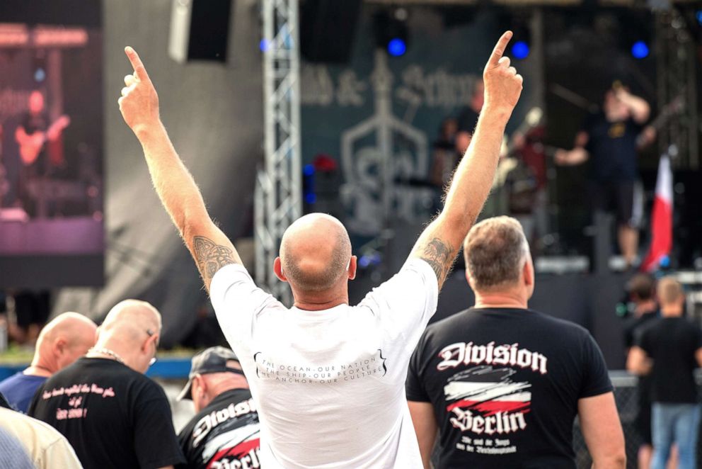 PHOTO: A man moves his arms to the music, which is played on the stage of the right rock festival Shild und Schwert, June 22, 2019. 