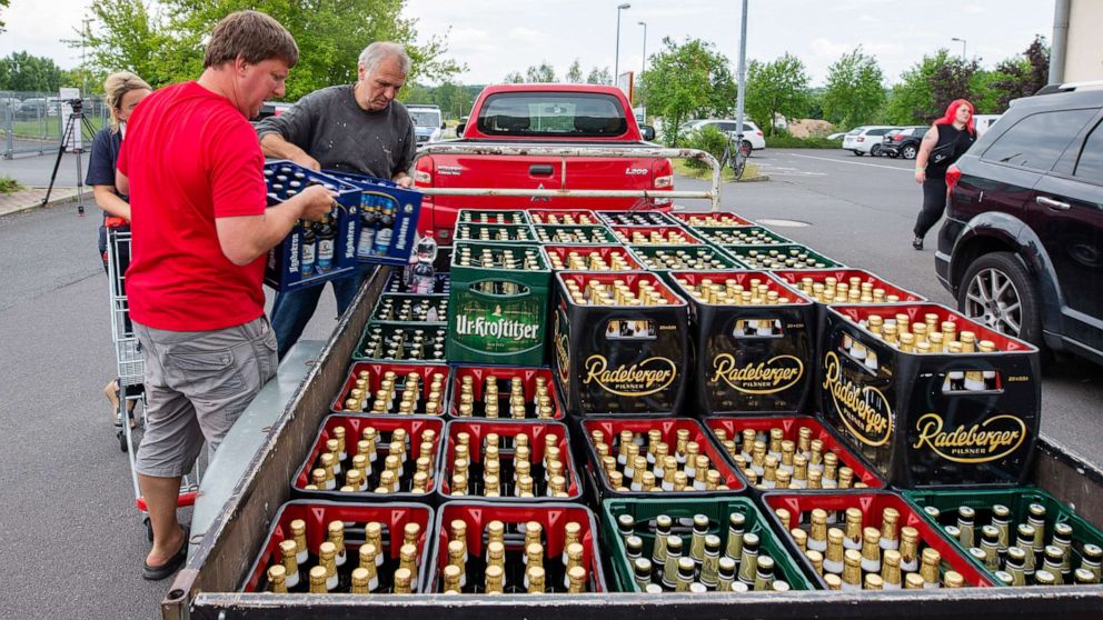 PHOTO: A woman and two men load beer crates near a local supermarket onto a trailer in Saxony, Ostritz, Germany, June 22, 2019.