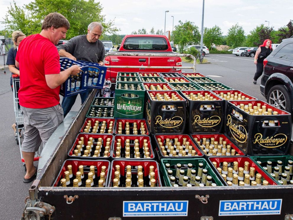 PHOTO: A woman and two men load beer crates near a local supermarket onto a trailer in Saxony, Ostritz, Germany, June 22, 2019.