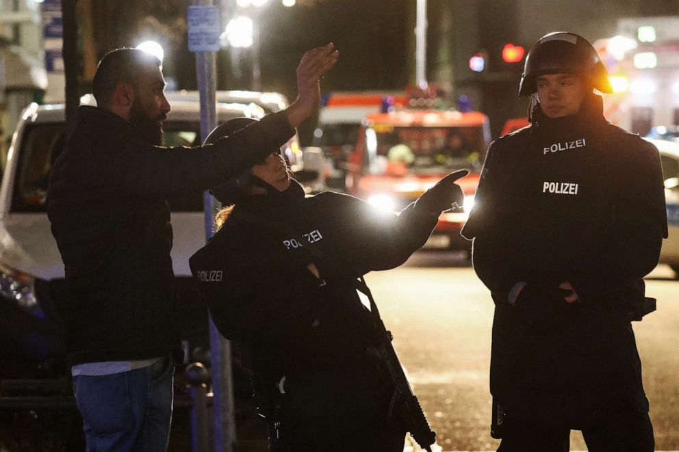 PHOTO: Police officers speak with a man as they secure the area after a shooting in Hanau, near Frankfurt, Germany, Feb. 19, 2020.