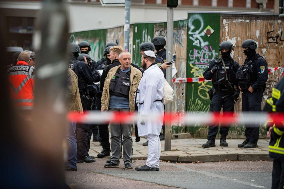PHOTO: In this Oct. 9, 2019, file photo, rescued parishioners of the Jewish community and police forces stand near the scene of a shooting that has left two people dead in Halle, Germany.