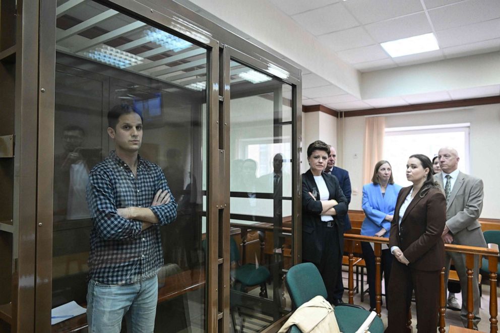 PHOTO: US journalist Evan Gershkovich, arrested on espionage charges, stands inside a defendants' cage at Moscow City Court in Moscow, Russia. U.S. Ambassador to Russia Lynne Tracy stands nearby in a blue blazer. April 18, 2023.