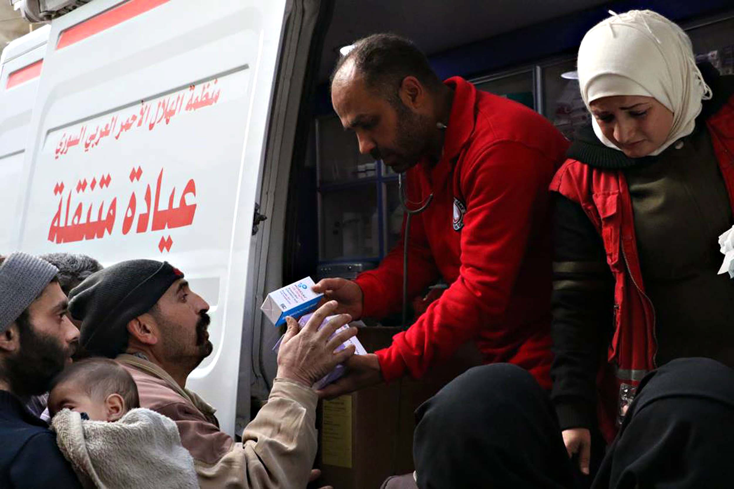 PHOTO: A handout photo made available by the Syrian Arab Red Crescent shows volunteers distributing medical supplies to people in Douma, eastern Ghouta, Syria, March 5, 2018. 